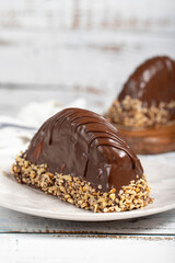 Chocolate and banana cake. Malaga cake on wooden background. Large chocolate eclairs