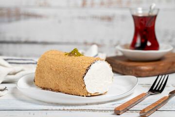 Creamy roll cake. Portion cake on wooden background
