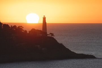 Coucher de soleil en bord de mer sur le phare de la presqu'île du Cap Ferrat depuis le Cap de Nice