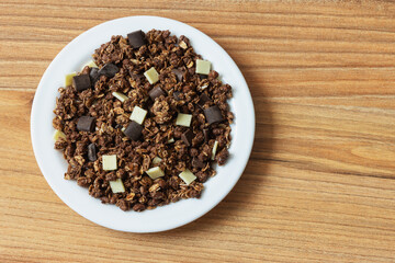 Top view of granola with oatmeal and chocolate on a plate