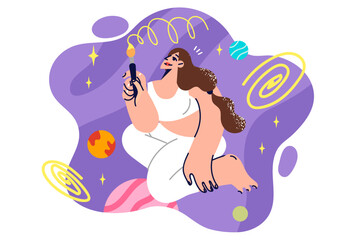 Woman paints space using brushes and watercolor paints, sitting on knees among planets