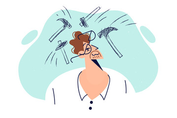 Man suffers from headache due to intracranial pressure problems standing among hammers