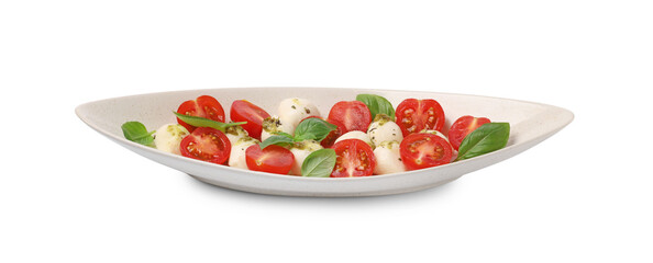 Plate of tasty Caprese salad with mozzarella, tomatoes, basil and pesto sauce isolated on white