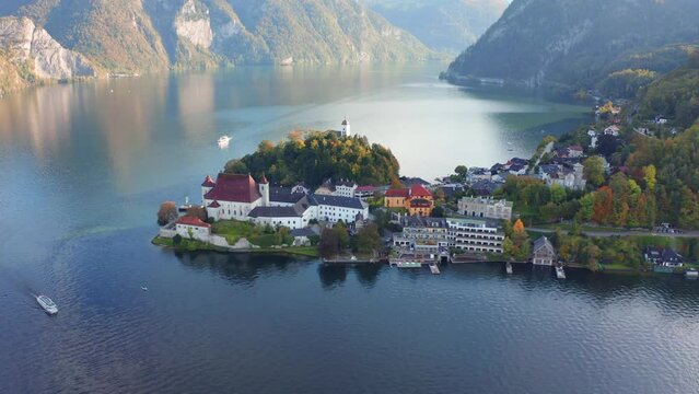4k drone flight moving to the side footage (Ultra High Definition) of Maria Kronung church. Aerial autumn scene of Traunsee lake in Austrian Alps with Traunstein peak on background, Austria, Europe..