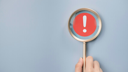 Attention caution warning concept. Magnifying glass focus on red page with exclamation error mark for important alert signal, Hazard, risk ,danger background with copyspace. - obrazy, fototapety, plakaty