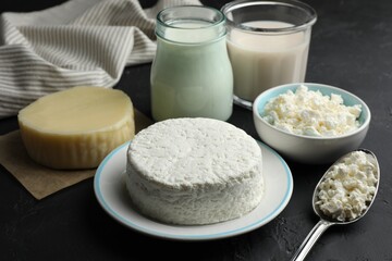 Many different lactose free dairy products on black textured table, closeup