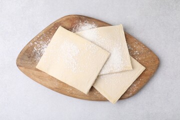 Raw puff pastry dough on white table, top view
