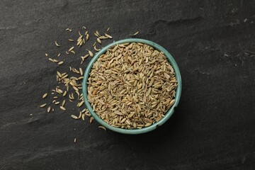 Fennel seeds in bowl on gray table, top view - obrazy, fototapety, plakaty