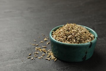 Fennel seeds in bowl on gray table, closeup. Space for text