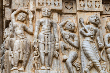 Fototapeta na wymiar Sculptures of musicians and dancers on hindu holy temple wall at day