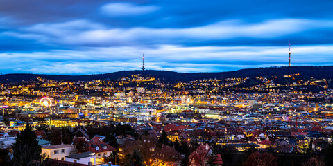 Stuttgart blue hour panorama with colorfully illuminated buildings in winter season. Evening twilight with TV towers overlooking the capital of Baden-Württemberg and busy city cauldron. Wide angle. - obrazy, fototapety, plakaty
