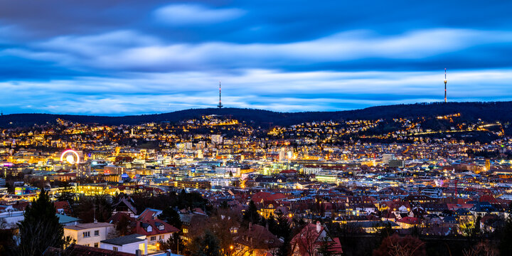 Fototapeta Stuttgart blue hour panorama with colorfully illuminated buildings in winter season. Evening twilight with TV towers overlooking the capital of Baden-Württemberg and busy city cauldron. Wide angle.