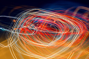 Blurred moving red, yellow and white lights on a german Autobahn seen through the windshield while...