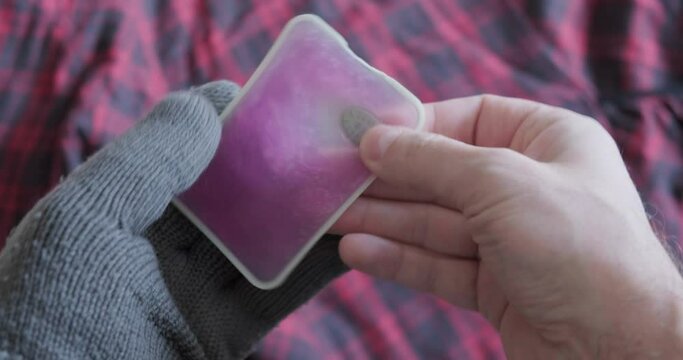 Activation and crystallization of a crystallisation-type reusable hand warmer. Accessory for cold hands and feet in Winter weather.