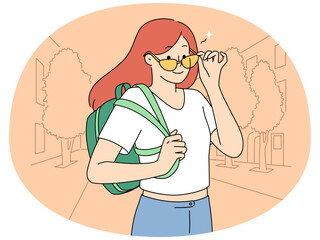 Smiling girl with backpack on street