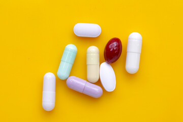 Colorful capsules and pills on blue background.