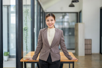 Half-body portrait of businesswoman standing at desk in office.