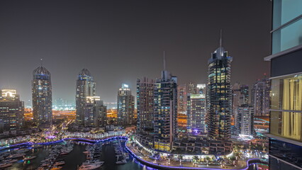 Panorama showing Dubai marina tallest skyscrapers and yachts in harbor aerial night timelapse.