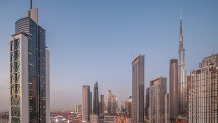 Fototapeta premium Aerial view of Dubai Downtown skyline with many towers day to night timelapse.