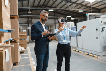 Warehouse managers talking logistics using VR, controlling stock levels. Virtual reality in...