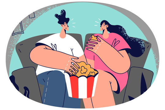Happy couple watching movie eating popcorn