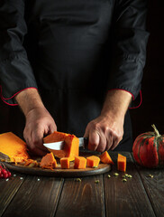 A chef prepares pumpkin porridge with his hands in a restaurant kitchen. Working medium on the...