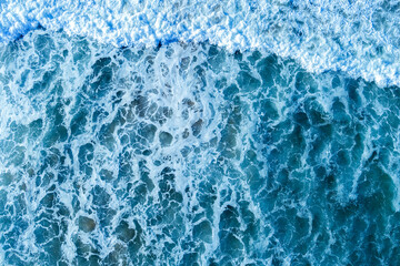 Ocean surf. Waves roll onto the shore. View from above. Natural abstract background