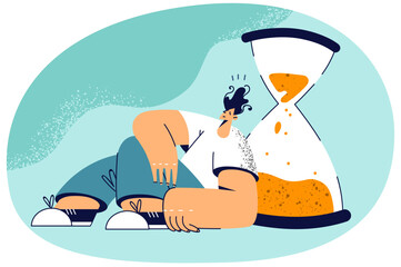 Tired man near sandglass