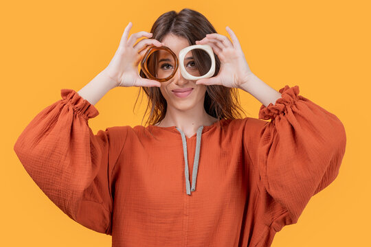Woman making eyeglasses shape with bangles in studio