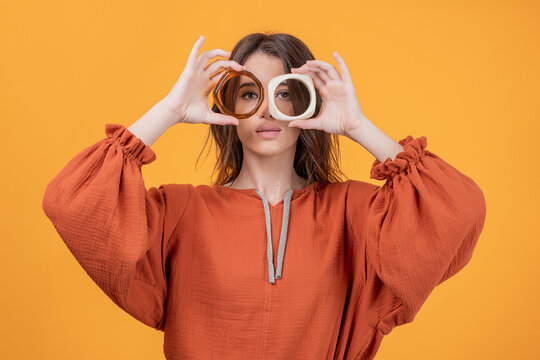 Woman making eyeglasses shape with bangles in studio