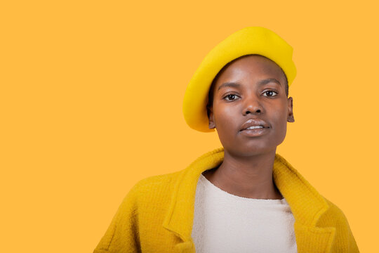 Young woman wearing yellow flat cap and coat