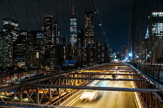 Fototapeta Manhattan city lights viewed from Brooklyn bridge perspective.