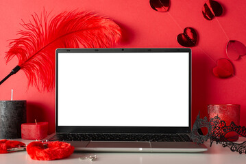 Explore virtual desires with side view of laptop, candles, mask, and adult toys—furry handcuffs...