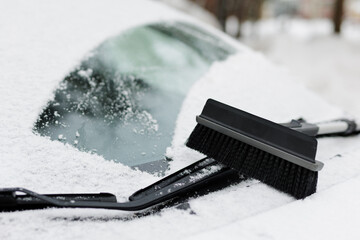 car covered by snow and brush on the windshield - obrazy, fototapety, plakaty