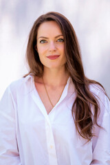 Portrait of beautiful young woman with green eyes and brunette haired against white background