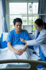 An Asian male patient lies in a hospital bed and is carefully looked after by a doctor. Doctor giving advice to male patient Working on health disease diagnosis