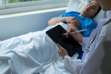 An Asian male patient lies in a hospital bed and is carefully looked after by a doctor. Doctor giving advice to male patient Working on health disease diagnosis