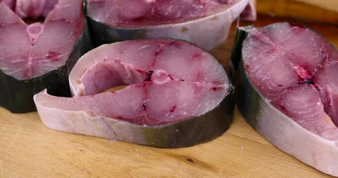 pieces of sea fish during cooking, raw yellow-tailed fish during cutting for cooking