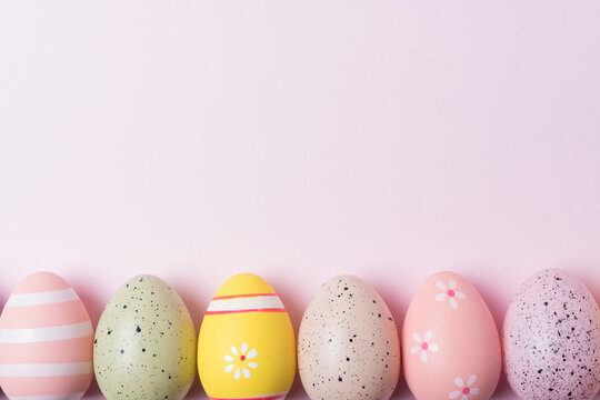 Colorful Easter eggs on pink background. Minimal Easter concept. Flat lay.