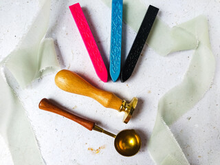 Colorful wax seal stamps and wax bead on a white background