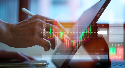 trading in stock market concept businessman using pen and digital tablet analysing virtual trading price graph