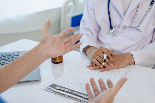 A young man is consulting with a psychiatrist while a patient undergoes psychiatric counseling by a doctor taking notes at the clinic. Encouragement, therapy, medical health concept Close-up pictures