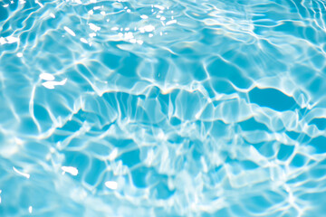 Bluewater waves on the surface ripples blurred. Defocus blurred transparent blue colored clear calm water surface texture with splash and bubbles. Water waves with shining pattern texture background.