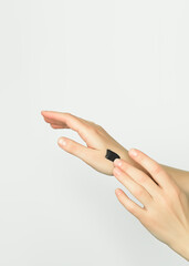 woman applies black carbon mask to her hands. hand skin care concept