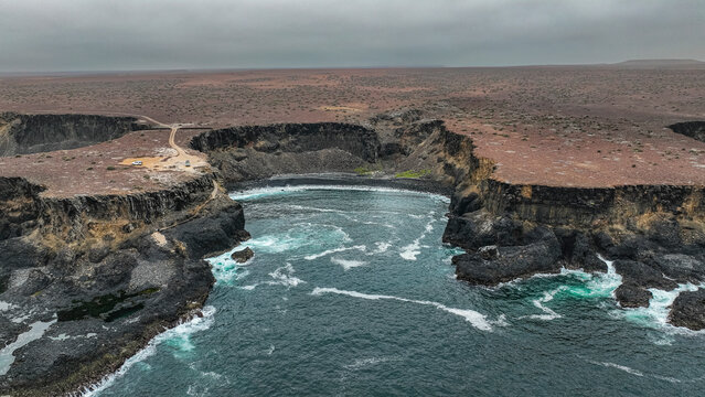 Aerial of the wild coastline with basalt pools on the Atlantic coastline, Dombe Grande, Namibre, Angola
