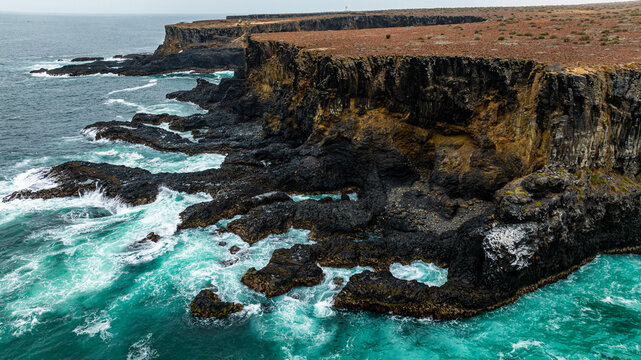 Aerial of the wild coastline with basalt pools on the Atlantic coastline, Dombe Grande, Namibre, Angola