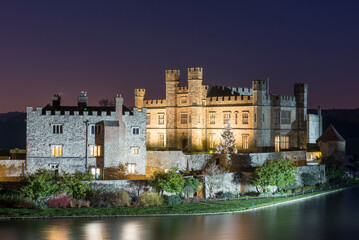 Leeds Castle and moat at night with decorated Christmas tree, near Maidstone, Kent, England
