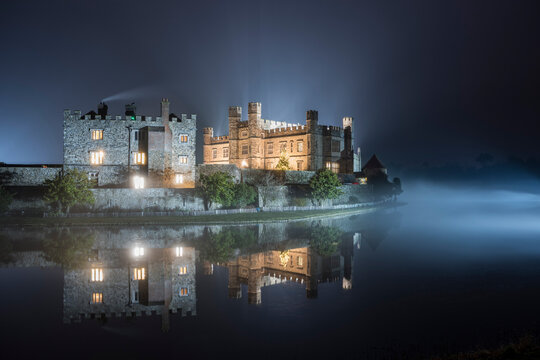 Leeds Castle illuminated in evening mist, winter, near Maidstone, Kent, England