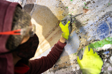 Confident and Devoted Art Restorer Working with a Scalpel on Old Stencil Designs Hidden Under Wall...