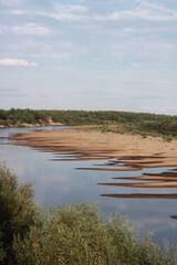 sandy uneven shore along the river in summer